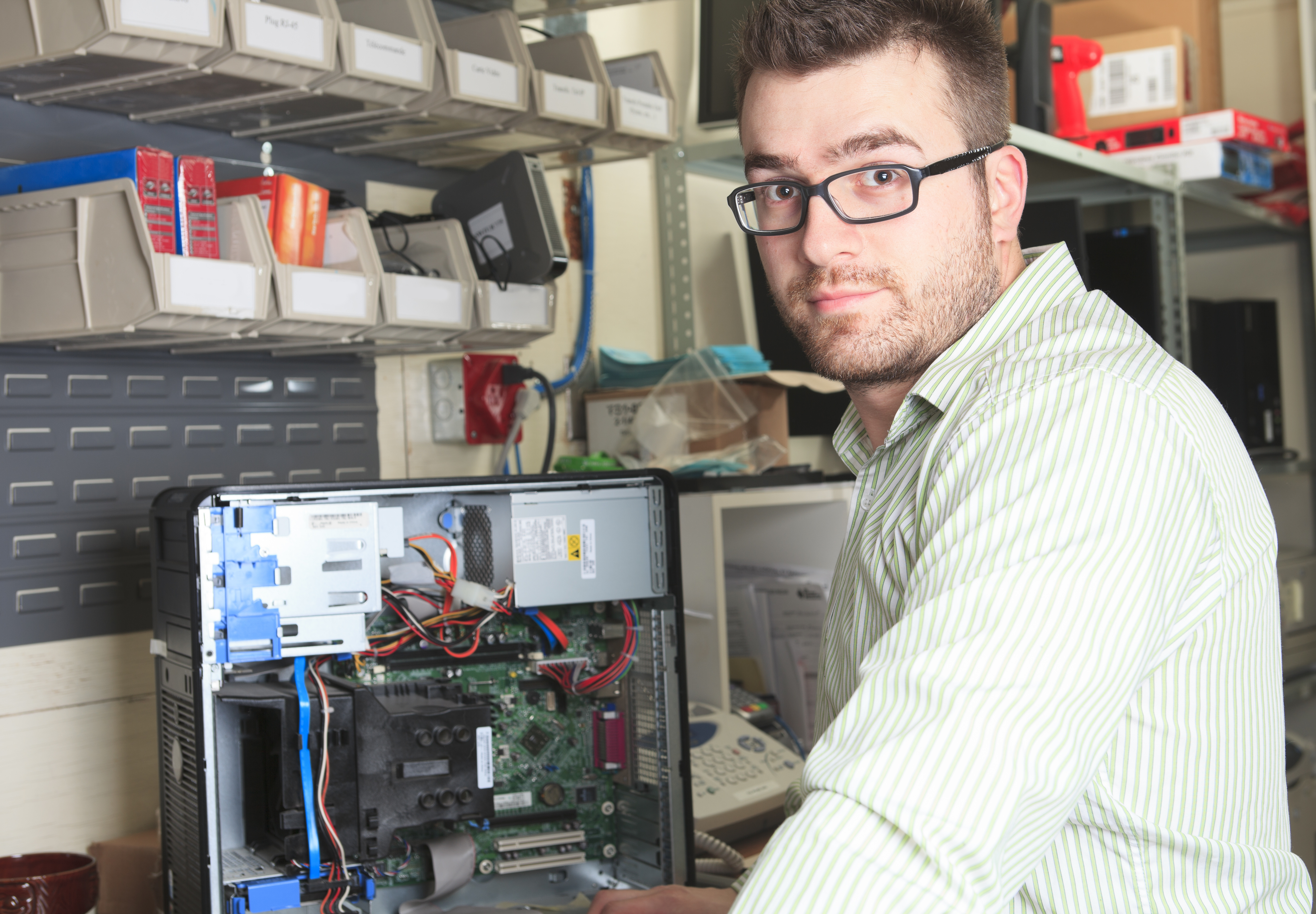 A happy worker technician at work with computer.